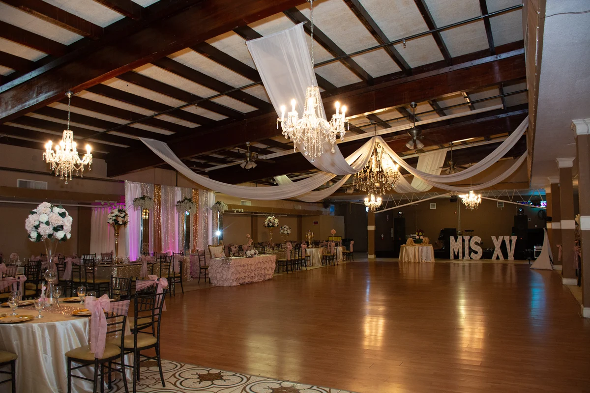 Ballroom dressed in pink for a quinceañera with a Mis XV backdrop